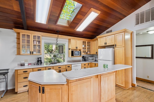 kitchen featuring white appliances, light hardwood / wood-style floors, a center island, and lofted ceiling with skylight