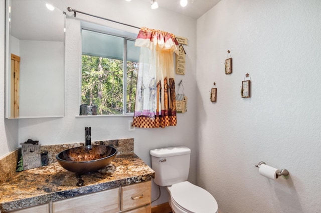half bathroom featuring toilet and vanity