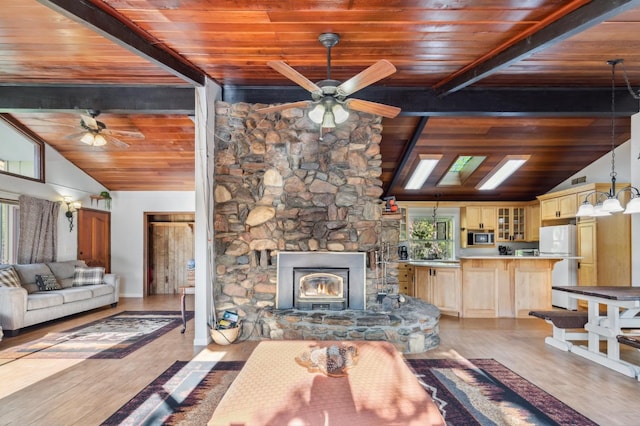 living room with ceiling fan, beamed ceiling, light hardwood / wood-style flooring, wooden ceiling, and a fireplace