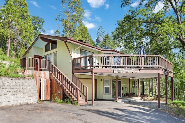 view of front of home with stairway, a wooden deck, and a carport