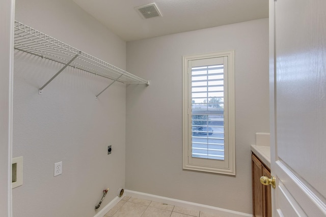 washroom featuring gas dryer hookup, hookup for an electric dryer, and light tile patterned flooring