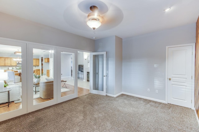 carpeted empty room featuring french doors and ceiling fan