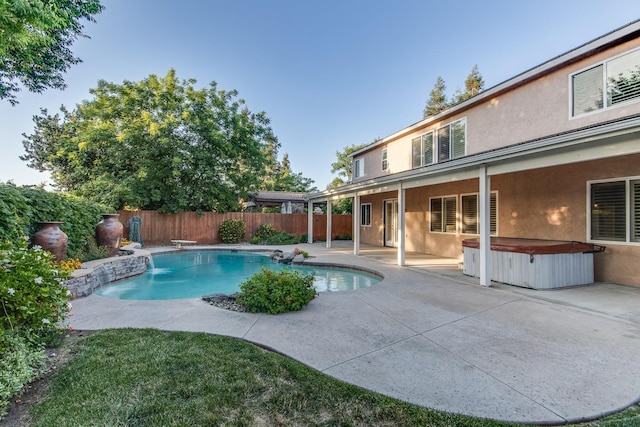 view of pool featuring a hot tub, a diving board, and a patio area