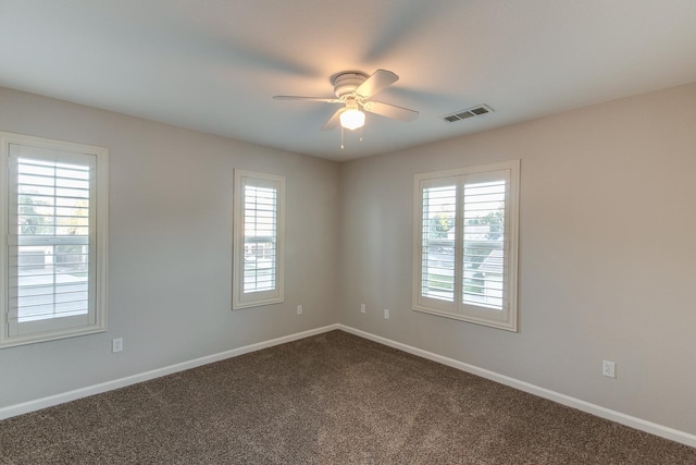 empty room with ceiling fan, plenty of natural light, and carpet flooring