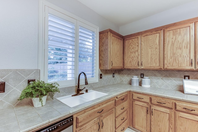 kitchen featuring sink, decorative backsplash, tile counters, and stainless steel dishwasher