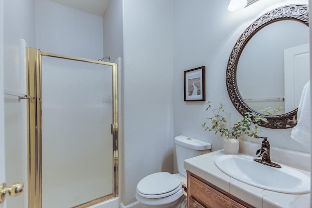 bathroom with a shower with door, vanity, and toilet