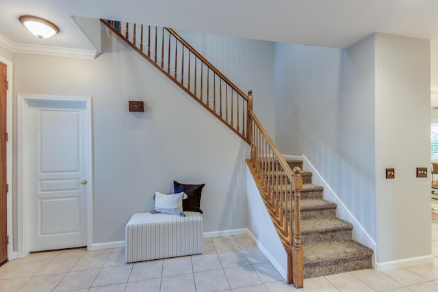 staircase with tile patterned flooring and crown molding