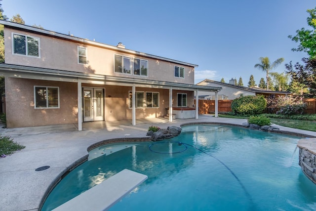 view of pool with a hot tub, a diving board, and a patio area