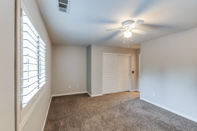 carpeted spare room with ceiling fan