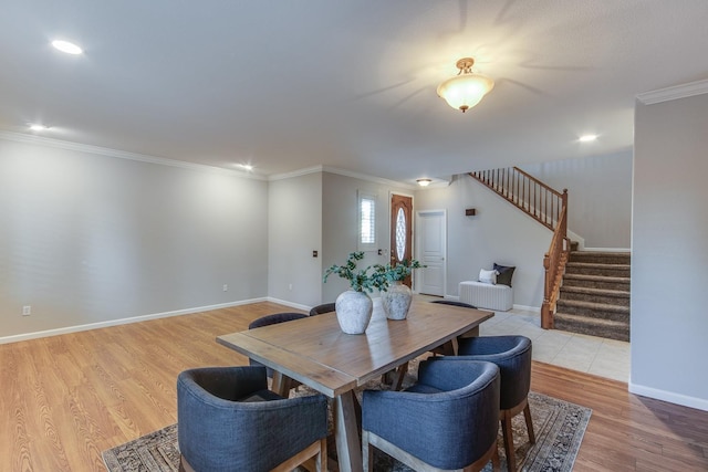 dining room with crown molding and light wood-type flooring