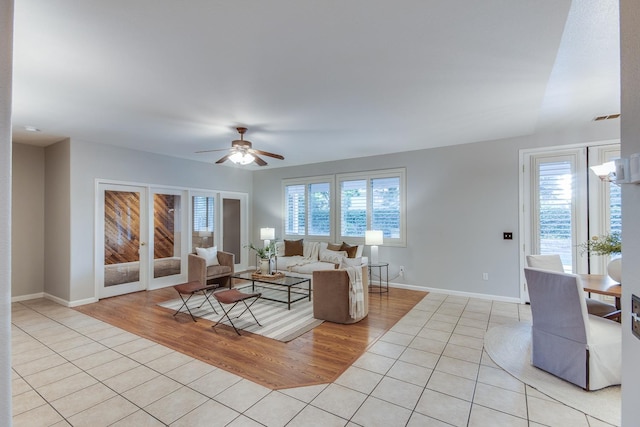 living room featuring a wealth of natural light, light tile patterned floors, and ceiling fan