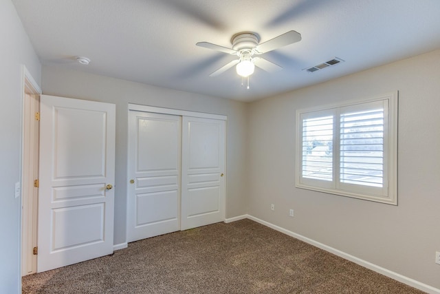 unfurnished bedroom featuring ceiling fan, a closet, and carpet