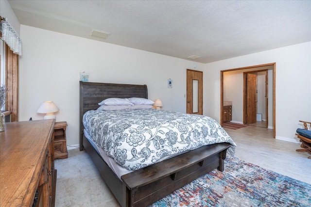 bedroom with a textured ceiling and ensuite bath