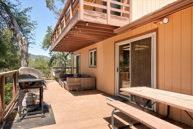 wooden terrace featuring an outdoor living space and grilling area