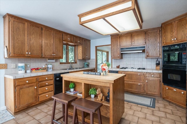 kitchen with backsplash, sink, black appliances, and light tile floors