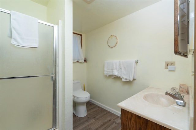 bathroom featuring an enclosed shower, large vanity, toilet, and hardwood / wood-style floors