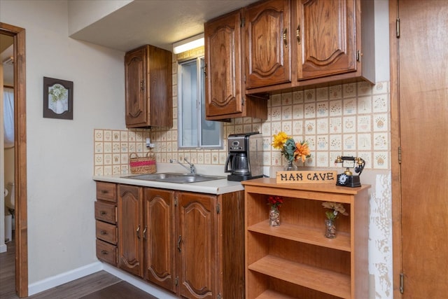 kitchen featuring sink, backsplash, and dark wood-type flooring