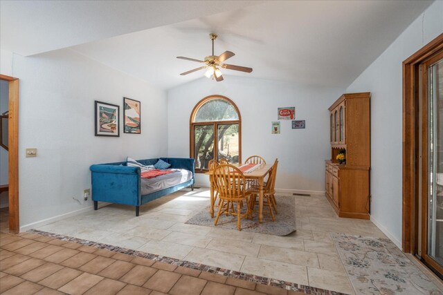 dining area with ceiling fan, light tile floors, and lofted ceiling