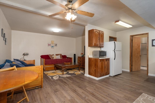 living room featuring ceiling fan and hardwood / wood-style flooring