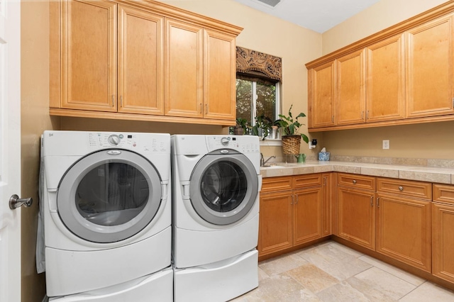 washroom featuring washer and clothes dryer, a sink, and cabinet space