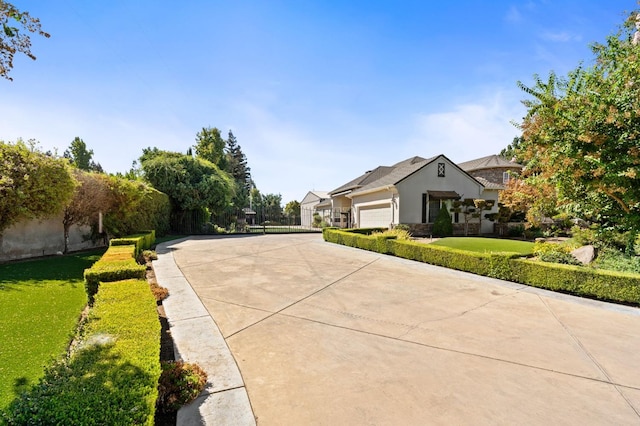 view of front of property with an attached garage, concrete driveway, and a front yard