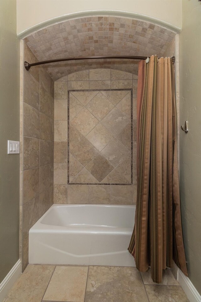 bathroom with shower / bath combination with curtain and baseboards