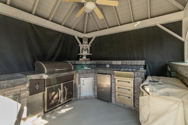 view of patio / terrace with an outdoor kitchen, area for grilling, ceiling fan, a gazebo, and a sink