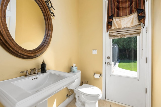 bathroom featuring a sink, toilet, and tile patterned floors