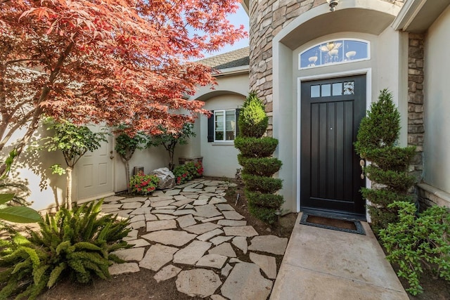 property entrance with stone siding and stucco siding