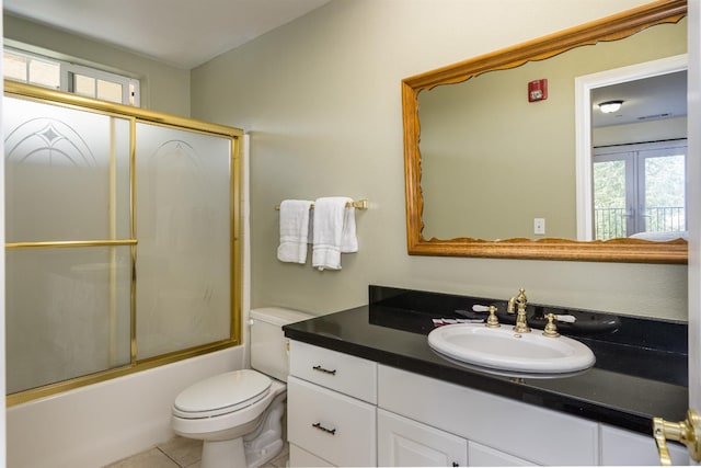 full bathroom with tile flooring, vanity, toilet, and enclosed tub / shower combo