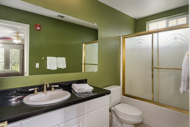 full bathroom featuring large vanity, a wealth of natural light, combined bath / shower with glass door, and toilet