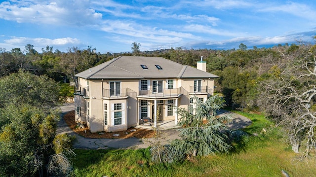 rear view of property with a patio and a balcony