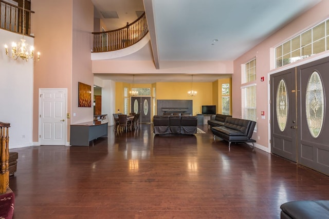 entrance foyer featuring beamed ceiling, a chandelier, dark hardwood / wood-style floors, and a towering ceiling