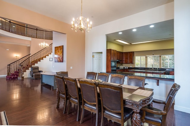 dining area with an inviting chandelier, sink, and dark hardwood / wood-style floors