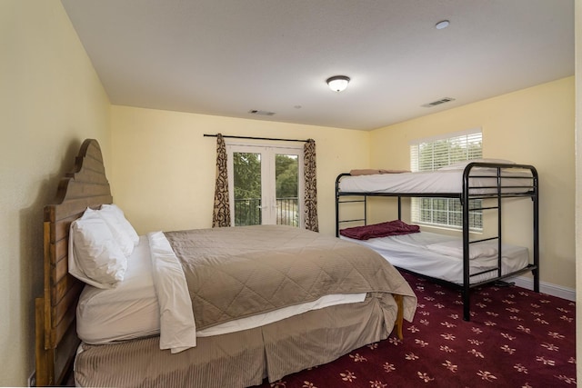 carpeted bedroom with french doors, access to exterior, and multiple windows