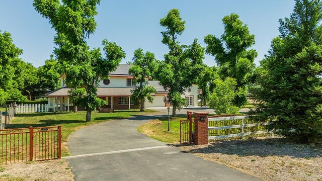 view of front of property with solar panels, a garage, and a front lawn