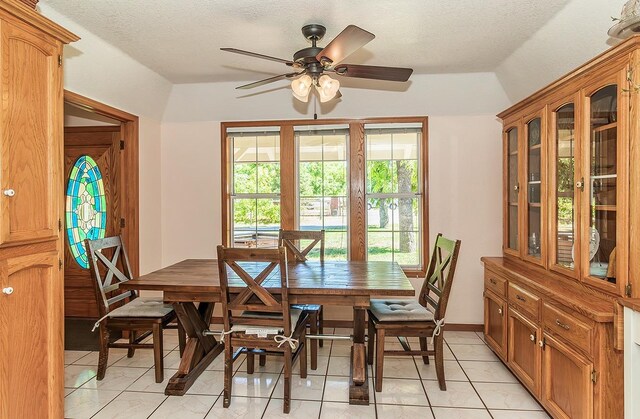 dining room featuring a textured ceiling, ceiling fan, and light tile patterned flooring