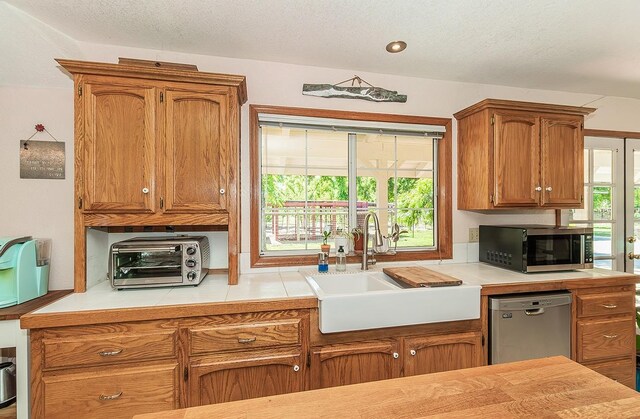 kitchen with a textured ceiling, sink, and stainless steel appliances