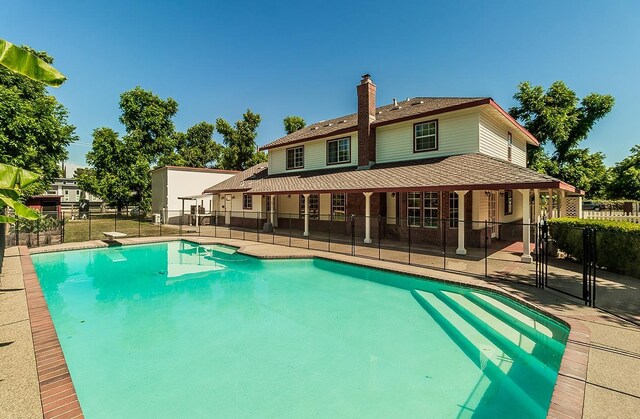 view of pool with a patio area and a diving board