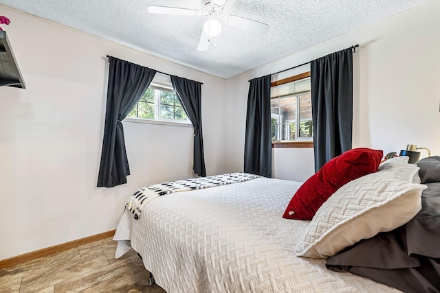 bedroom featuring wood-type flooring, a textured ceiling, and ceiling fan