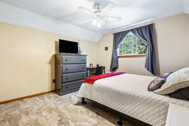 bedroom with a textured ceiling, ceiling fan, and lofted ceiling