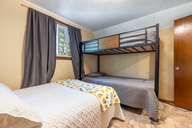 bedroom featuring light tile patterned flooring and a textured ceiling