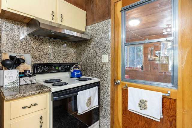 kitchen featuring electric stove, decorative backsplash, and dark stone countertops