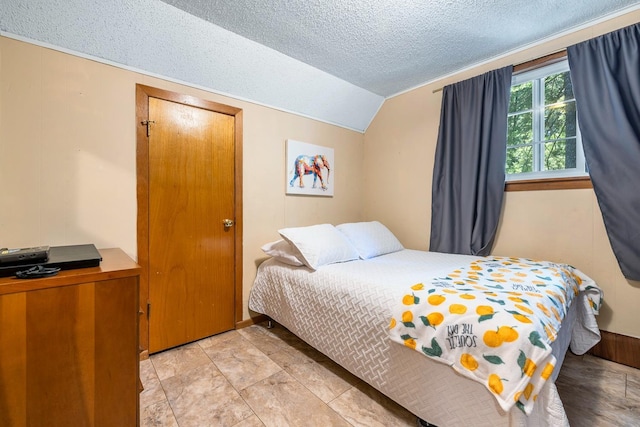 bedroom with a textured ceiling and lofted ceiling