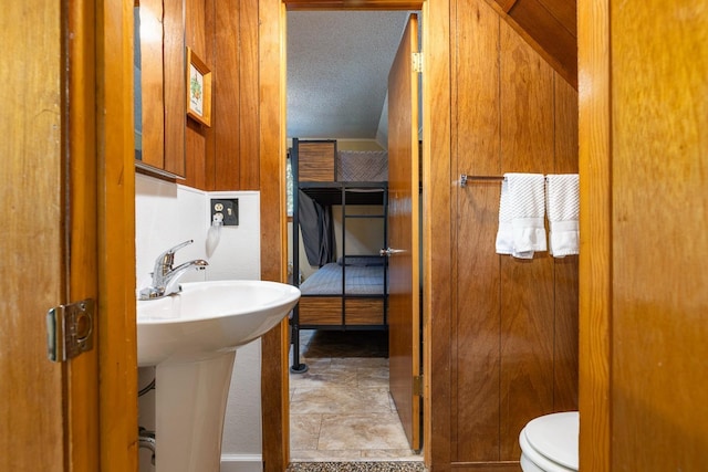 bathroom featuring a textured ceiling, toilet, and sink