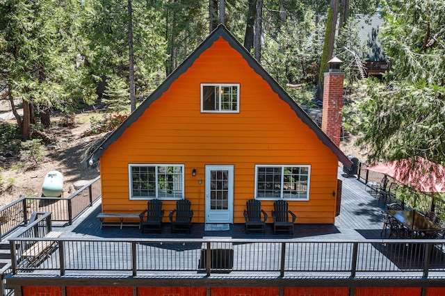 back of property with a wooden deck and an outdoor hangout area