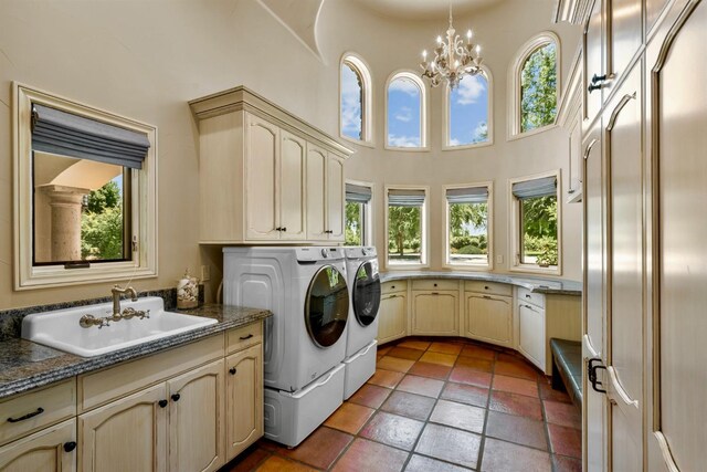 washroom with a healthy amount of sunlight, sink, cabinets, and washing machine and clothes dryer