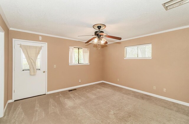 unfurnished room featuring a textured ceiling, light colored carpet, ceiling fan, and ornamental molding