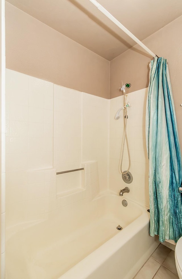 bathroom featuring tile patterned floors, shower / tub combo, and toilet