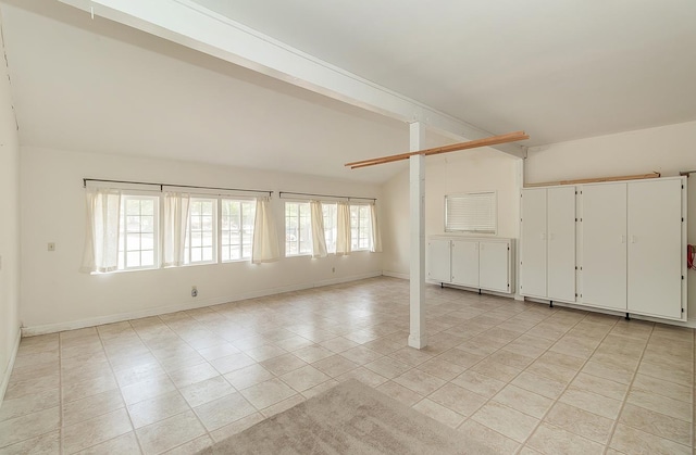 empty room featuring vaulted ceiling with beams